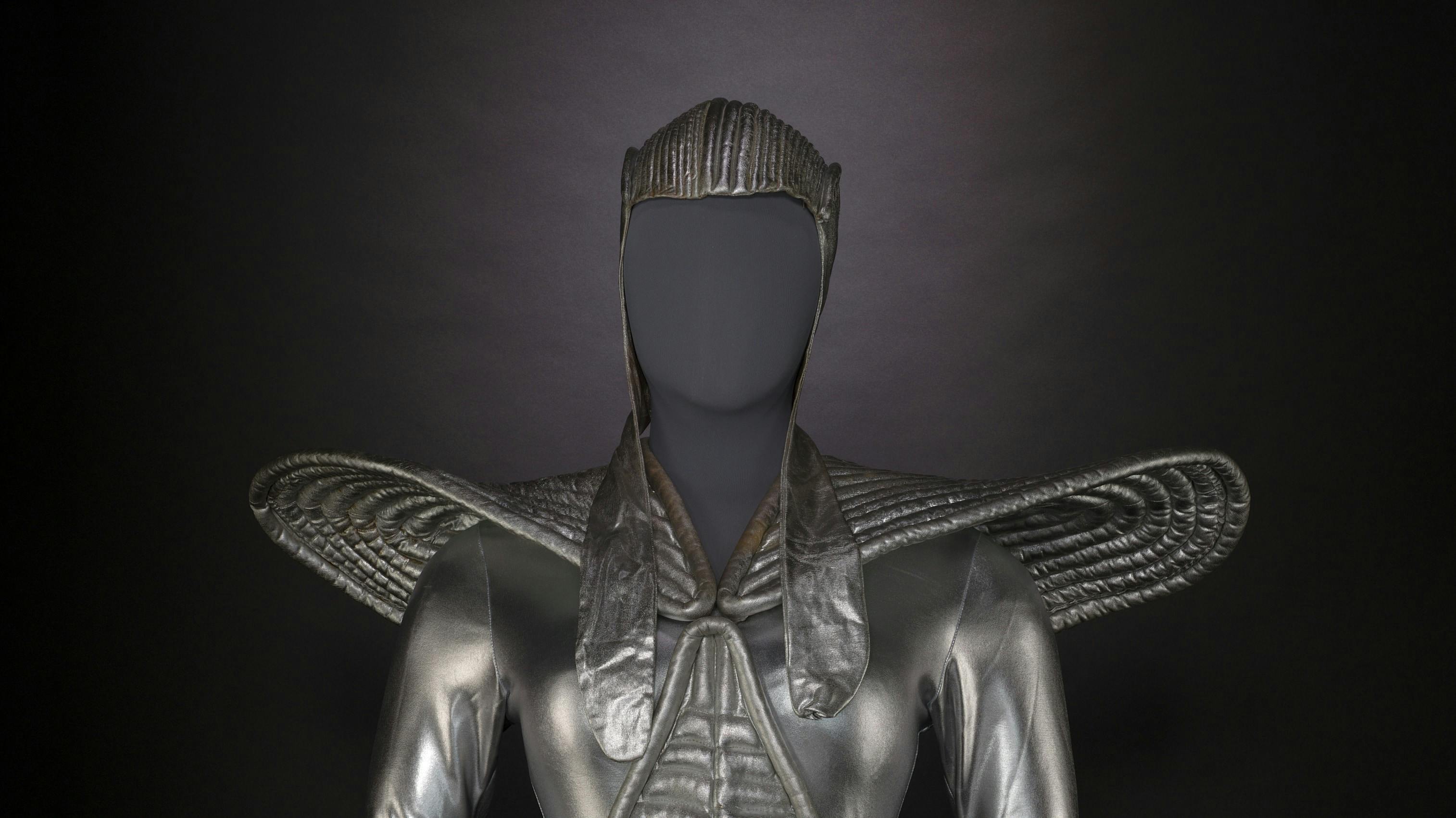 metallic silver costume with large shoulder protrusions