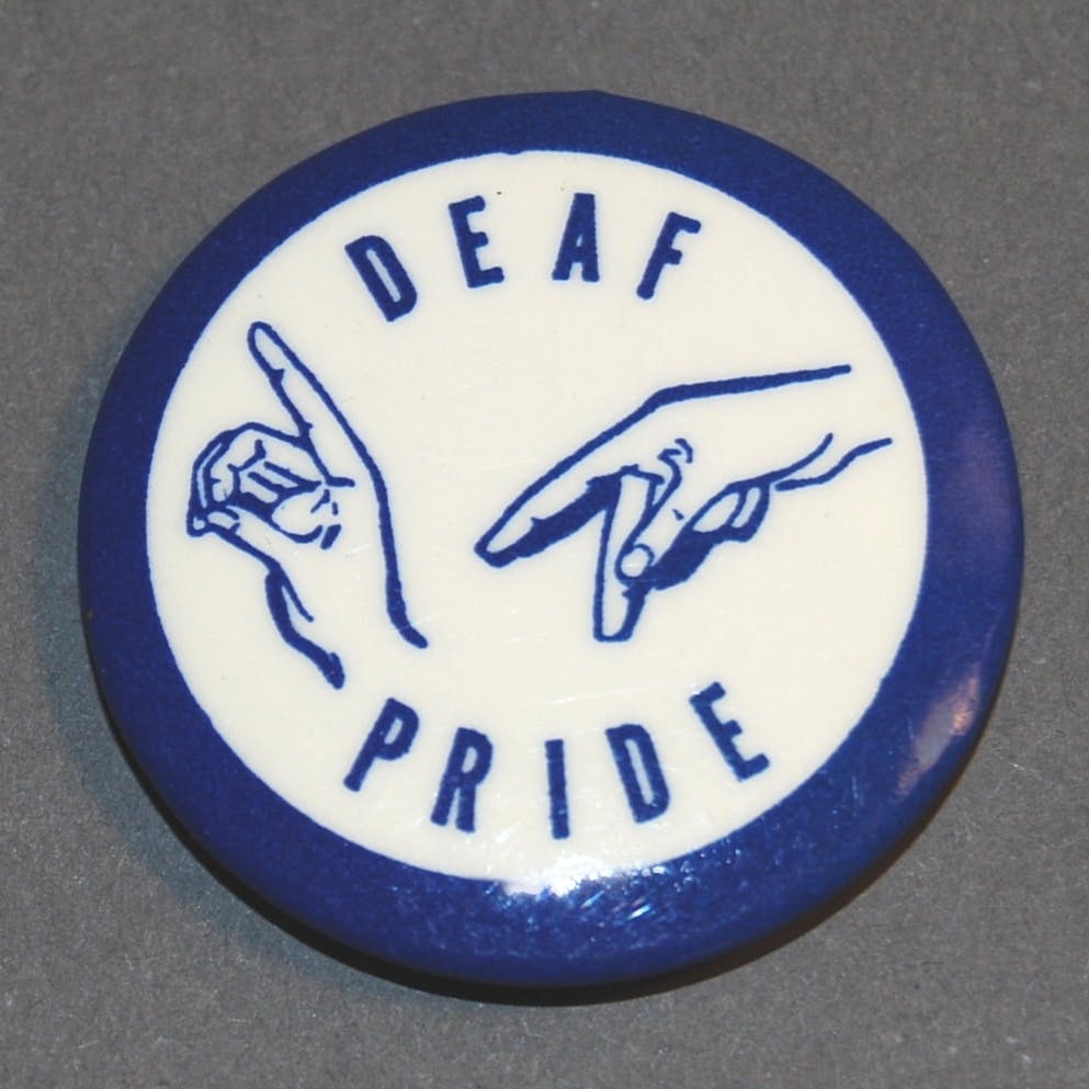 Button that reads "Deaf Pride" with hands signing